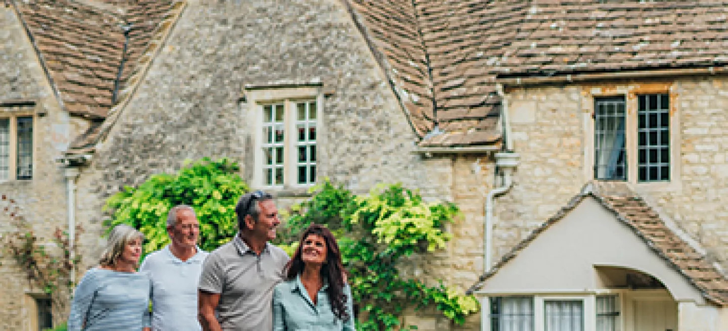 A group of guests walking past stone houses in a traditional village in France.
