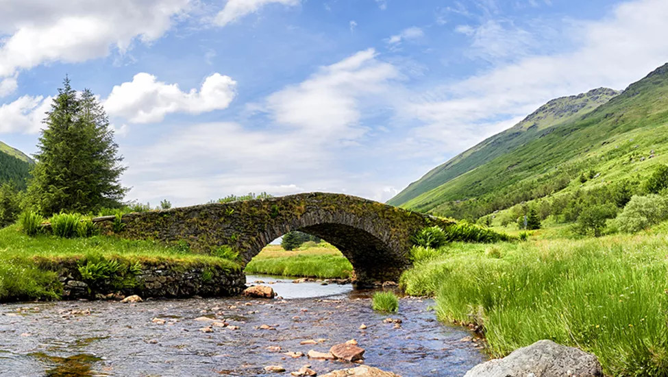 A view of the the Butter Bridge, a stone bridge in Glen Kinglas over a river leading to Loch Lomond.
