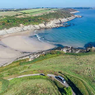 English coast with cliffs, a sandy beach, and a winding road.